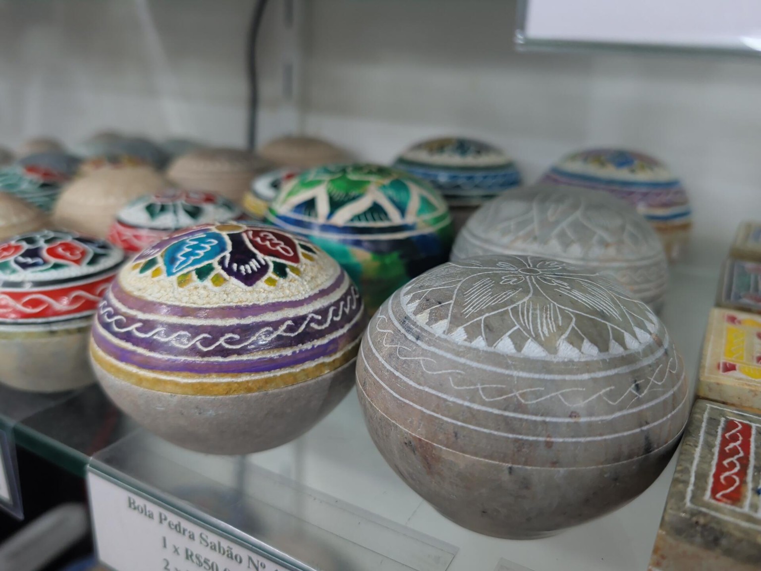 Piezas artesanales redondas de esteatita con dibujos tallados y pintura colorida